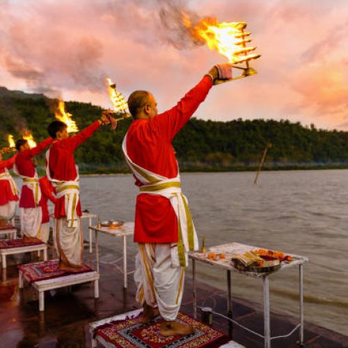 Rishikesh, Uttarakhand - August 03 2016: Priests in red robe in the holy city of Rishikesh in Uttarakhand, India during the evening light ceremony called Ganga arthi to worship river Ganga / Ganges.